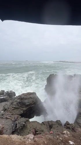 Rough seas crash against rocky coastline in Arica, Chile