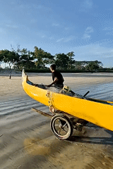 Fishermen tend traditional boat on Indonesian beach