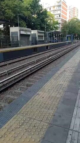 The video shows a train station in Buenos Aires, Argentina. The station is empty, with no people visible. The tracks are visible, as well as the platform. The station is named "Belgrano R". The video is taken from a stationary position.
