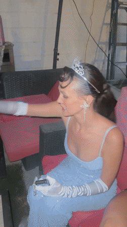 Woman in formal gown and tiara spotted on outdoor couch