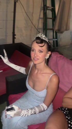 Woman in formal gown and tiara spotted on outdoor couch