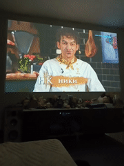 TV shows projected on walls in dimly lit rooms