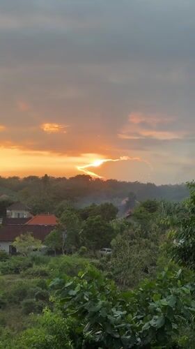 Golden sunset over red-roofed Kuta Selatan neighborhood
