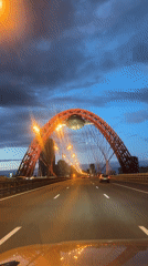 Evening traffic flows across Moscow's Zhivopisny Bridge at dusk