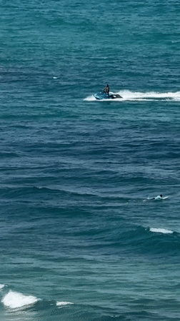 Netanya beach buzzing with water sports on a clear morning