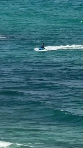 Netanya beach buzzing with water sports on a clear morning