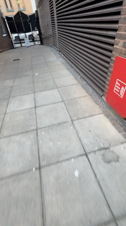 Woman in bomber jacket smiles while walking in London