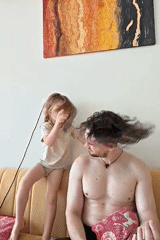 Father and child share playful moment on couch in Mumbai