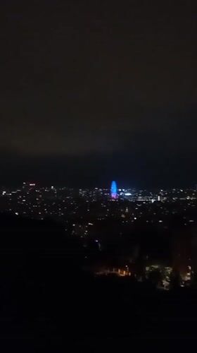 Barcelona's nighttime skyline from above, Ferris wheel glowing