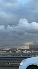 Vehicle passenger films church steeple, overcast skyline in Kotelniki
