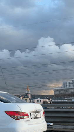 Vehicle passenger films church steeple, overcast skyline in Kotelniki
