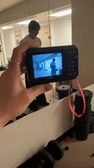 Person films workout session with digital camera in Khimki gym