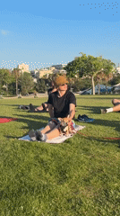 Outdoor yoga on a Tel Aviv seaside lawn, late afternoon.