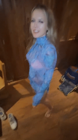 Woman dances with cat in wooden room, Sidemen