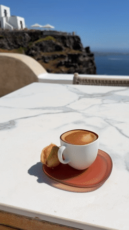 Coffee break overlooking Santorini's iconic white cliffside architecture