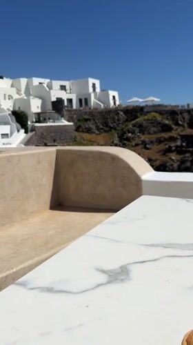 Coffee break overlooking Santorini's iconic white cliffside architecture