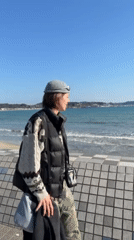 Woman films at Kamakura beach on sunny morning
