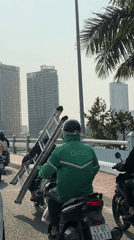 Motorcycle traffic observed on Đà Nẵng bridge includes delivery driver