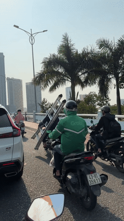 Motorcycle traffic observed on Đà Nẵng bridge includes delivery driver