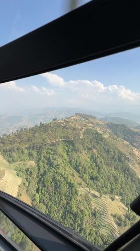 Helicopter flight documents green mountain landscapes near Kathmandu