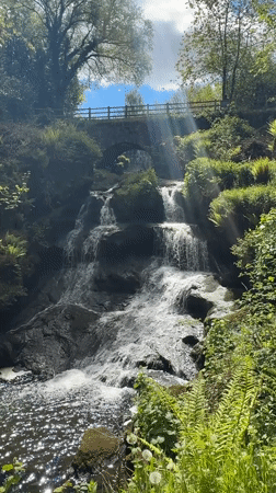 Waterfall with stone bridge captured in Thornliebank countryside
