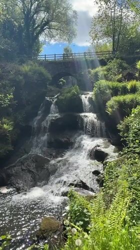 Waterfall with stone bridge captured in Thornliebank countryside