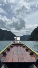 Longtail boat and mountain road through tropical terrain