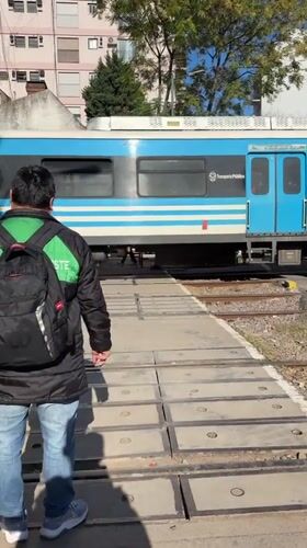 Buenos Aires pedestrians wait for public train at crossing