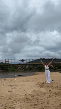Arms up on Mai Khao beach as a plane flies low overhead