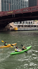 Kayaks and a motorboat navigate the Chicago River on a cloudy day