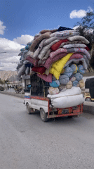 Pickup truck transports colorful bedding through Quetta streets