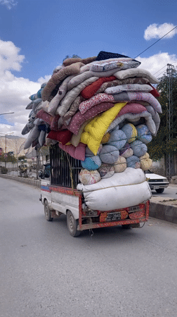 Pickup truck transports colorful bedding through Quetta streets