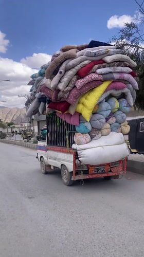 Pickup truck transports colorful bedding through Quetta streets