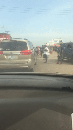 Gold minivan draws crowd on busy Abuja street