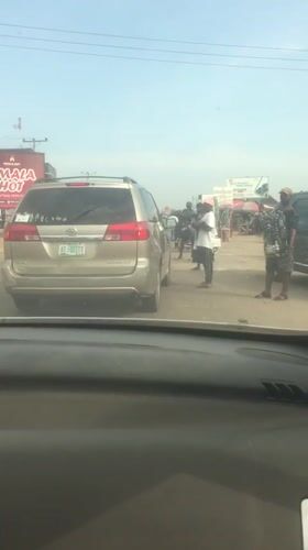 Gold minivan draws crowd on busy Abuja street