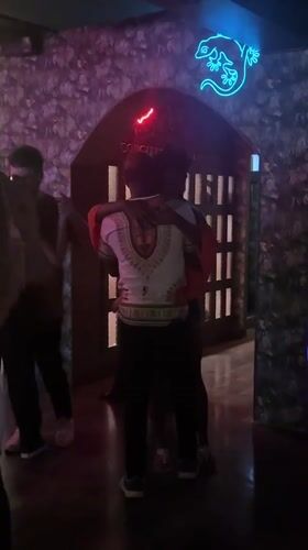 Couples dance in crowded Bangkok bar with tropical decor