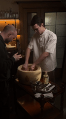 Chef demonstrates pasta-in-cheese-wheel preparation at St. Petersburg restaurant