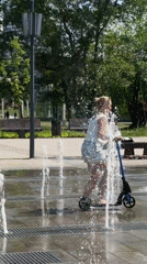 People play in fountain during sunny morning in Khimki