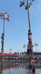 Panjat pinang pole climbing competition in muddy Kediri waters