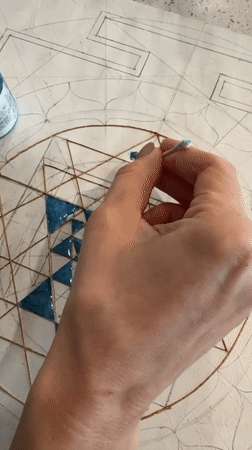 Artist applies blue paint to geometric design in Novosibirsk