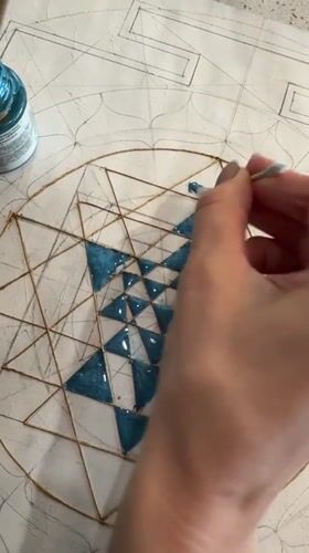 Artist applies blue paint to geometric design in Novosibirsk