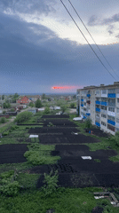 Red sun streak breaks through storm clouds over Russian town