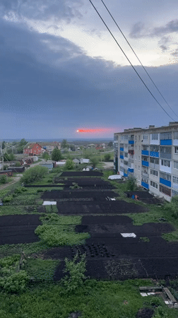 Red sun streak breaks through storm clouds over Russian town