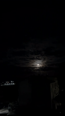 Full moon illuminates cloudy night sky over Burgas, Bulgaria