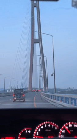 Vehicle crosses Russian flag-colored bridge to Russky Island