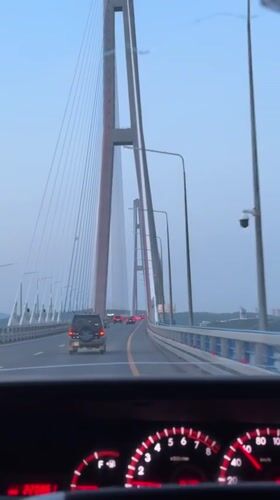 Vehicle crosses Russian flag-colored bridge to Russky Island