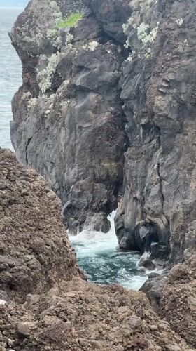 Tourists explore Porto Moniz volcanic pools under cloudy skies