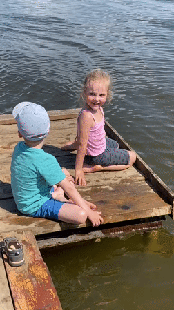 Children play on dock with dog in Votkinsk