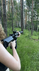 Woman practices rifle shooting in Russian forest near Vasilyevo