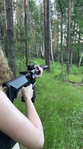 Woman practices rifle shooting in Russian forest near Vasilyevo